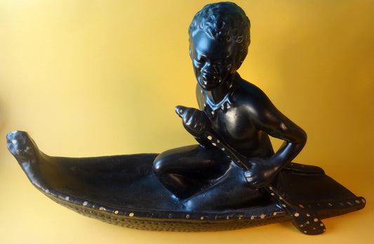 Antagelig afrikansk kvinde i båd, fremstillet af støbt og bemalet gips.