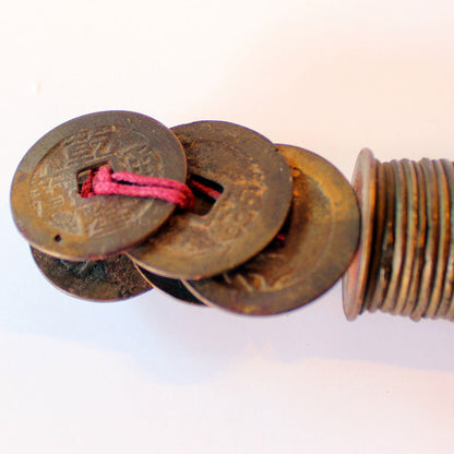 Mønterne er holdt sammen med bomuldsnor i rødt og hvidt