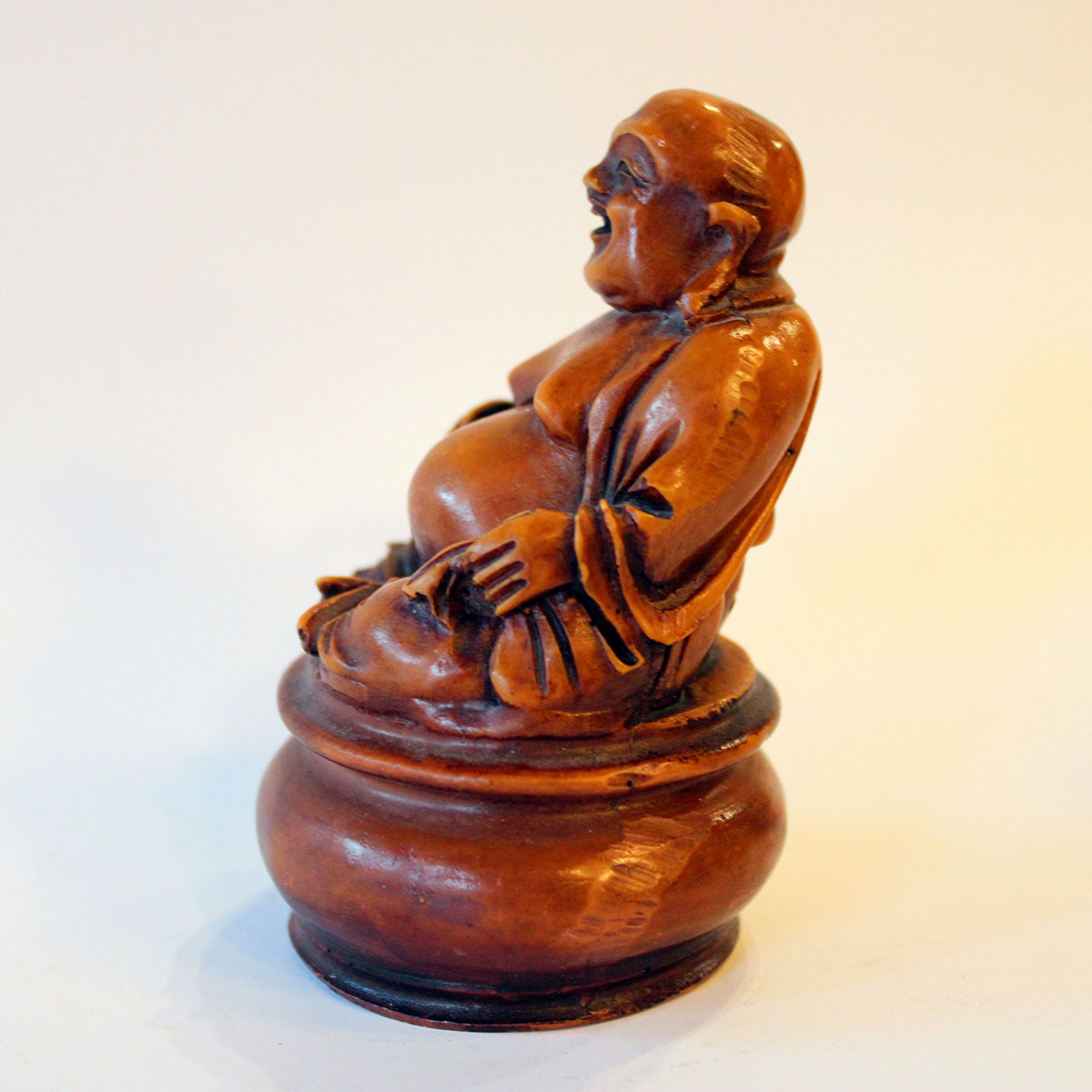 Figuren viser Buddha siddende på trone/pude