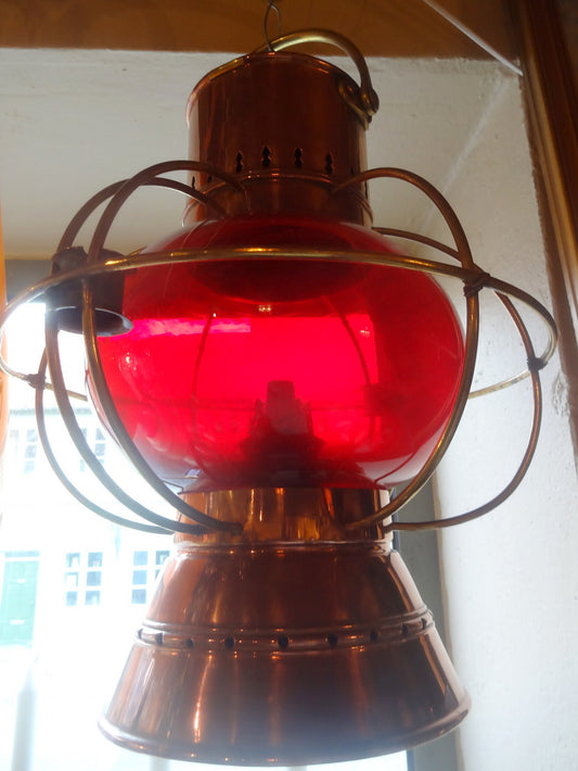 Kobberlygten med rød glasterning. Lygten er i fuldstændig original stand, med den originale brænder. Lampen virker.