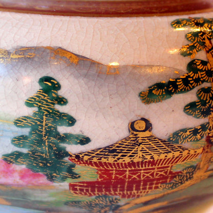 Vasen er dekoreret med huse og landskaber i farver samt guld